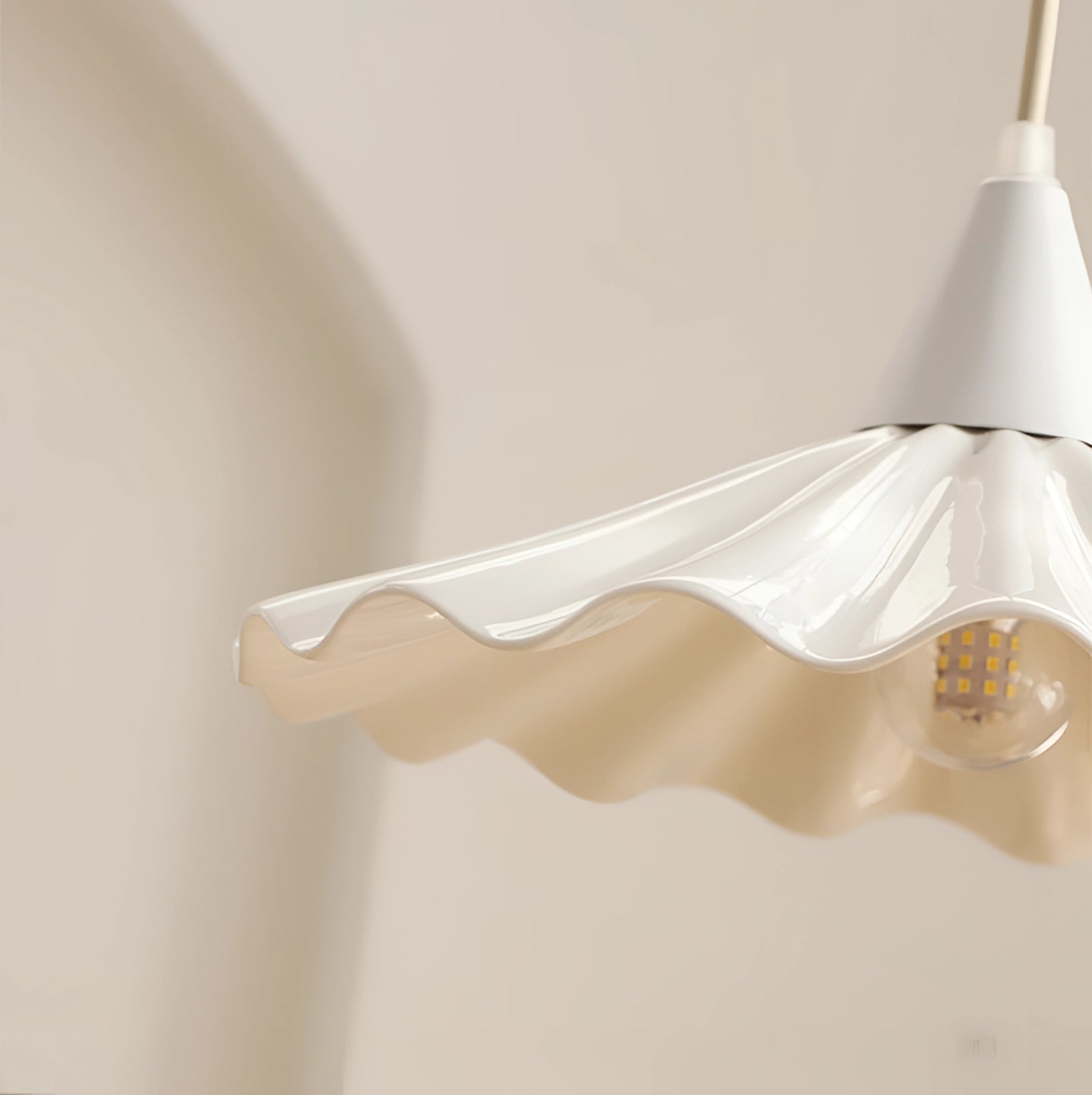Modern decorative ceiling lamp with scallop-edged design, featuring an LED pendant light hanging above a wooden table.