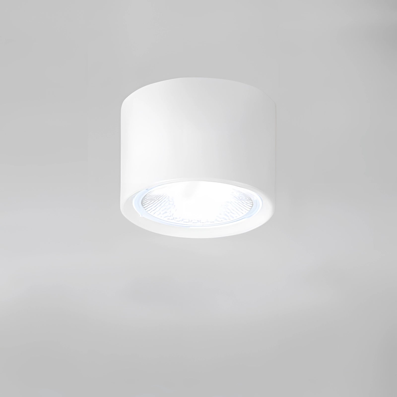Small white Scandinavian LED spotlight with a light wood finish, featuring a cylindrical design and warm light emission (3000K), mounted on a ceiling as part of modern kitchen lighting.