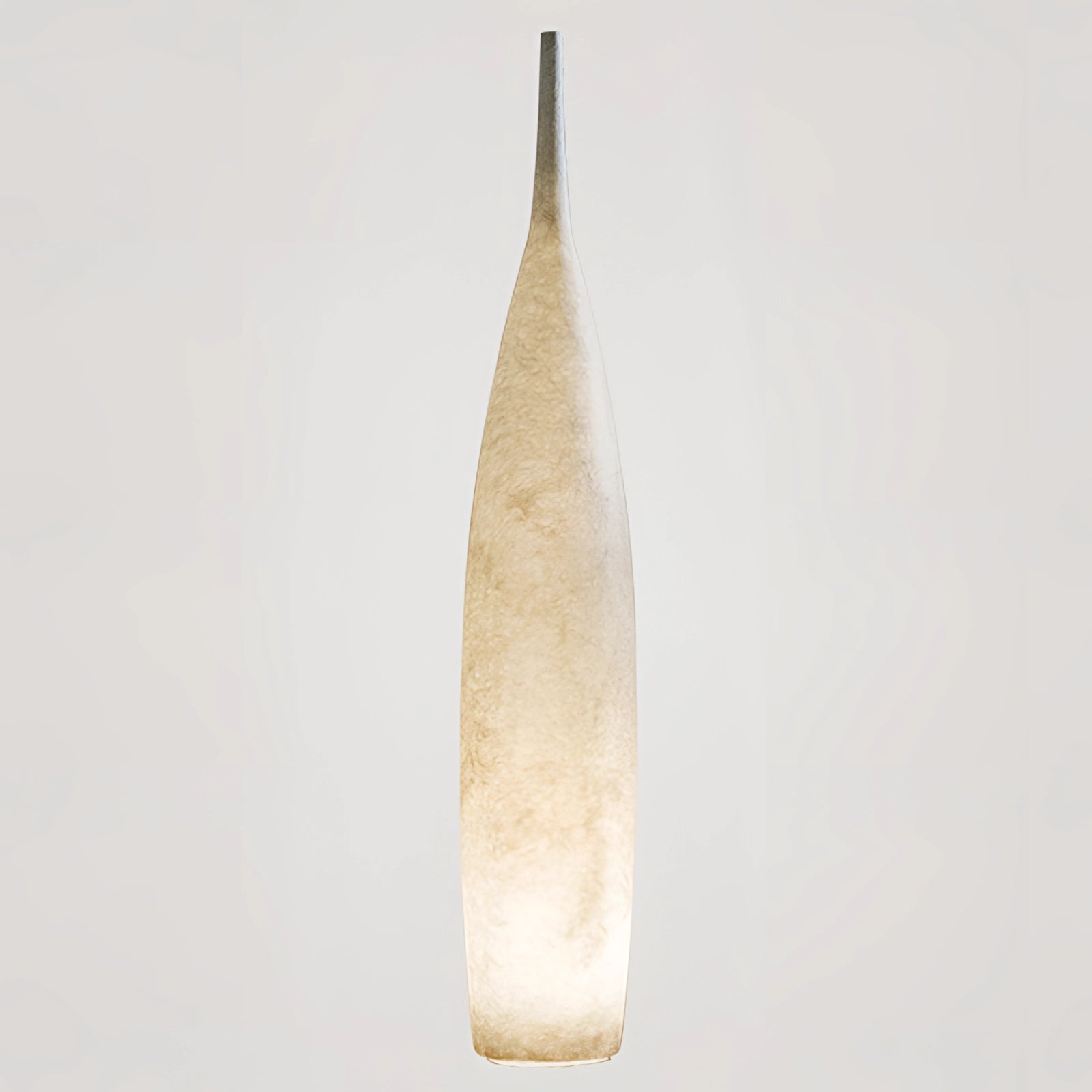 Tall narrow ceramic vase with a distressed finish, embodying Scandinavian minimalist design, placed on a surface with natural elements like twigs and feathers nearby.