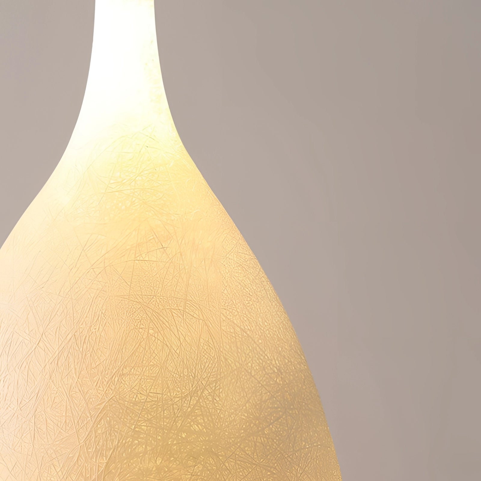 Tall narrow ceramic vase with a distressed finish in a Scandinavian minimalist style, displayed with a simple twig arrangement against a wooden backdrop.