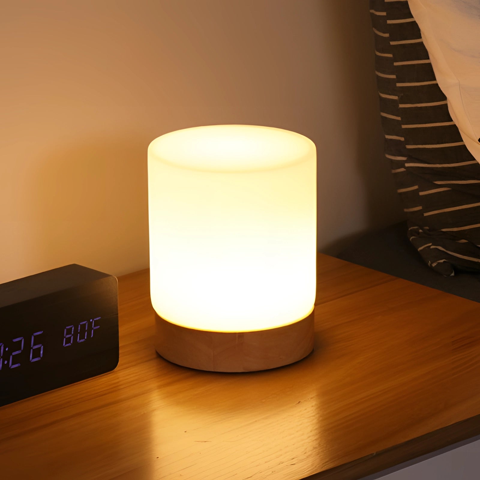 Scandinavian minimalist table lamp with a wooden base and LED light, emitting a warm, inviting glow.