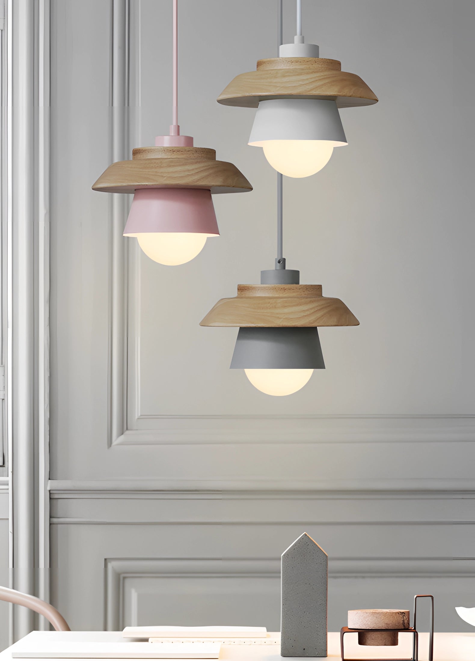 Scandinavian minimalist gray wooden pendant light fixture hanging from the ceiling, set in a modern interior with a white and gray color palette, featuring clean lines and an understated design.