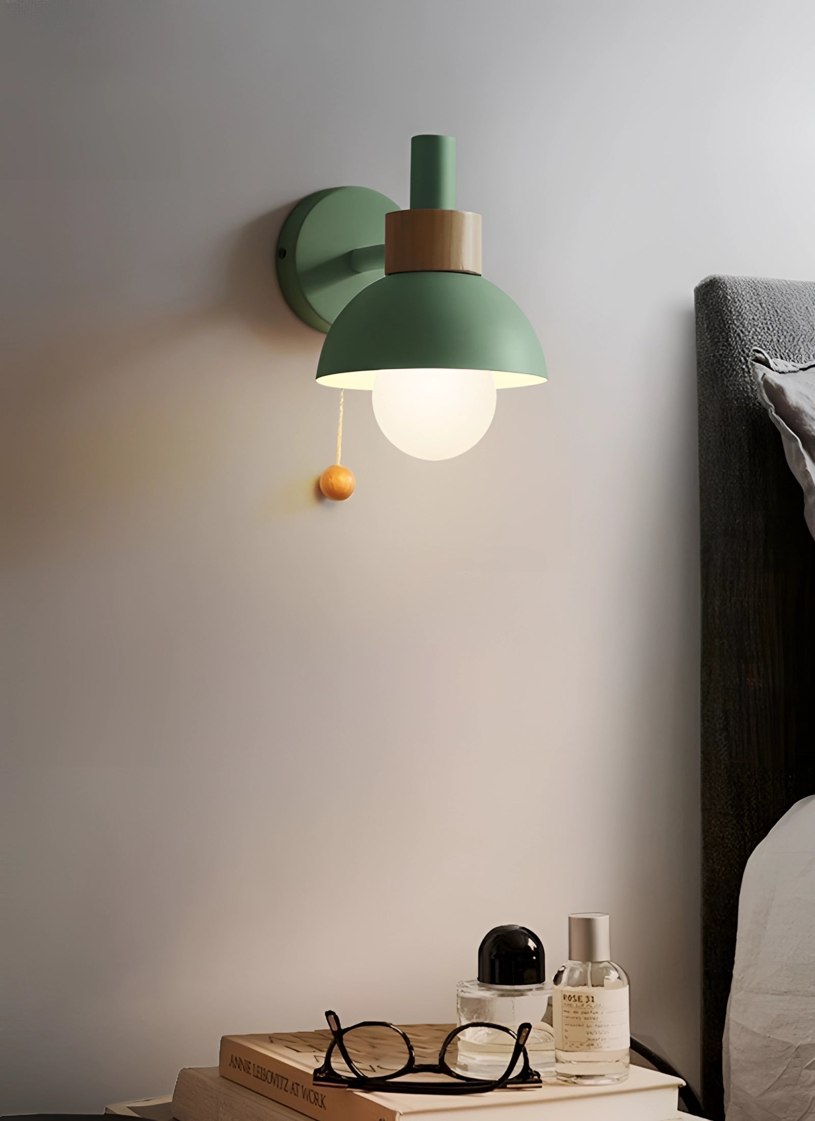 Modern minimalist Scandinavian pastel wall sconce in green, featuring an adjustable lamp with a textile-covered shade and wooden accents, mounted on a wall in a stylish living room interior.