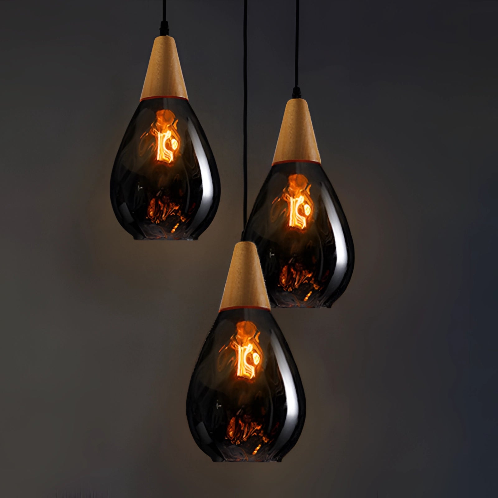
A Scandinavian teardrop pendant light featuring a smoked glass shade and wood accent, in a smoke gray color, hanging from the ceiling.