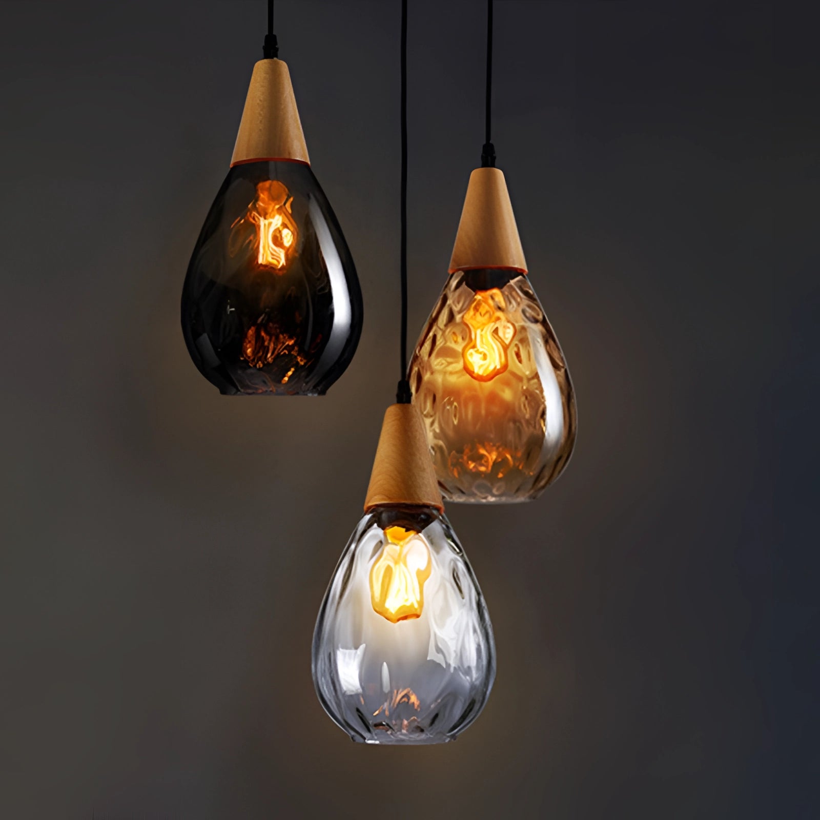 Scandinavian teardrop pendant light featuring smoked glass with a wood accent, hanging from the ceiling, showcasing warm amber lighting with a visible light bulb.