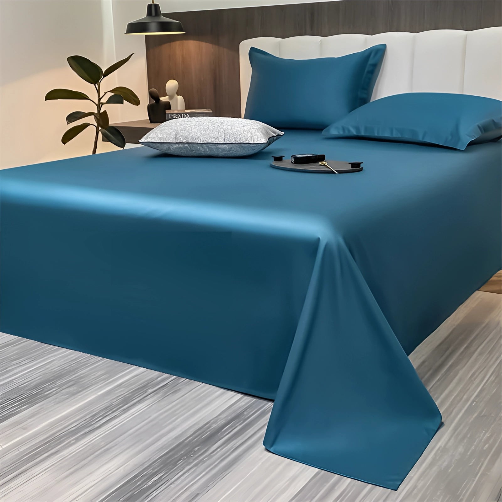 
Luxurious marine blue silky bed sheets in a minimalist bedroom setting, featuring a modern decor style with a touch of azure accents and decorative elements.
