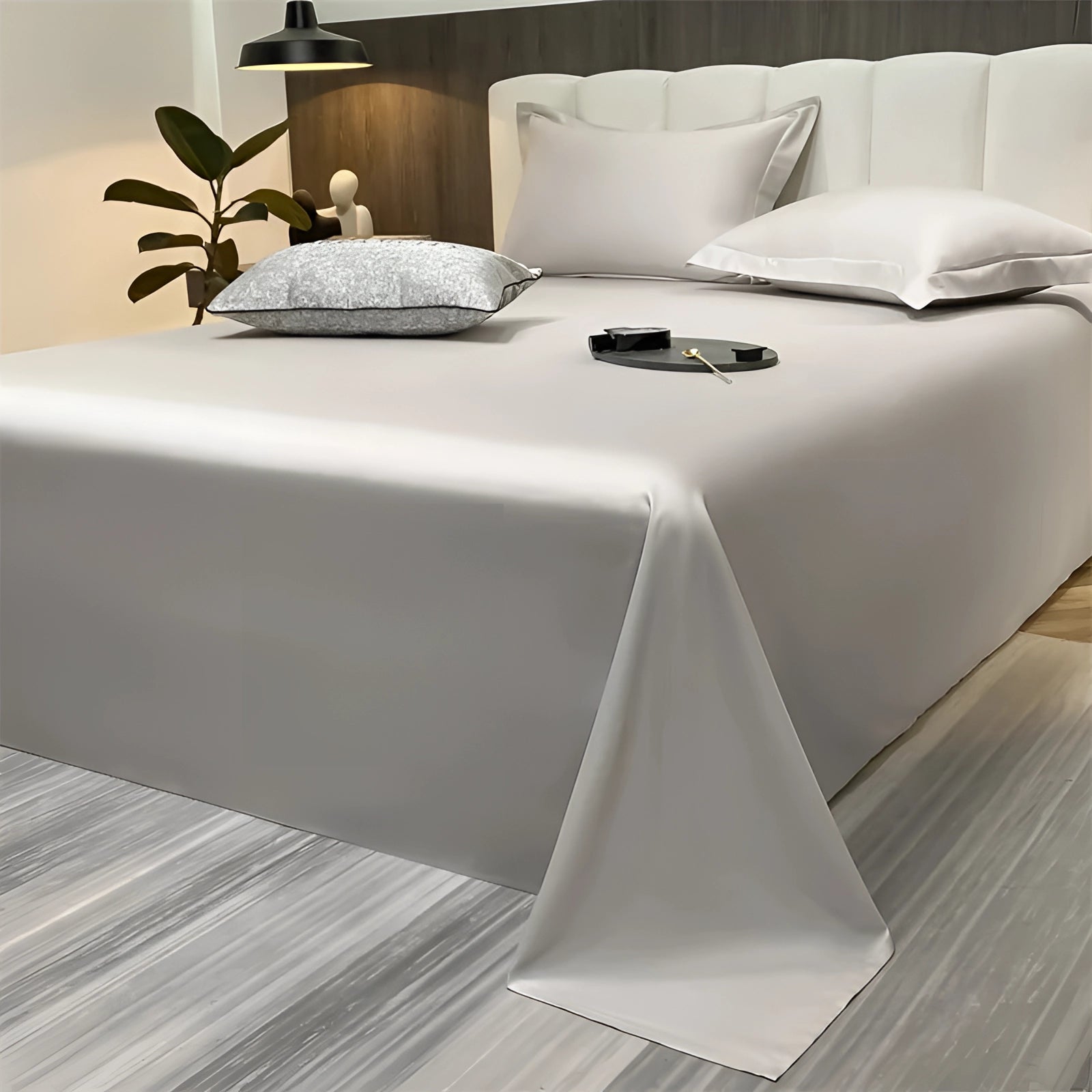 Sea green silky luxury bed sheets in a modern minimalist decor setting, displayed neatly on a bed with a pearl color variant, size 245x265cm, surrounded by a serene, white, and wood-accented interior.