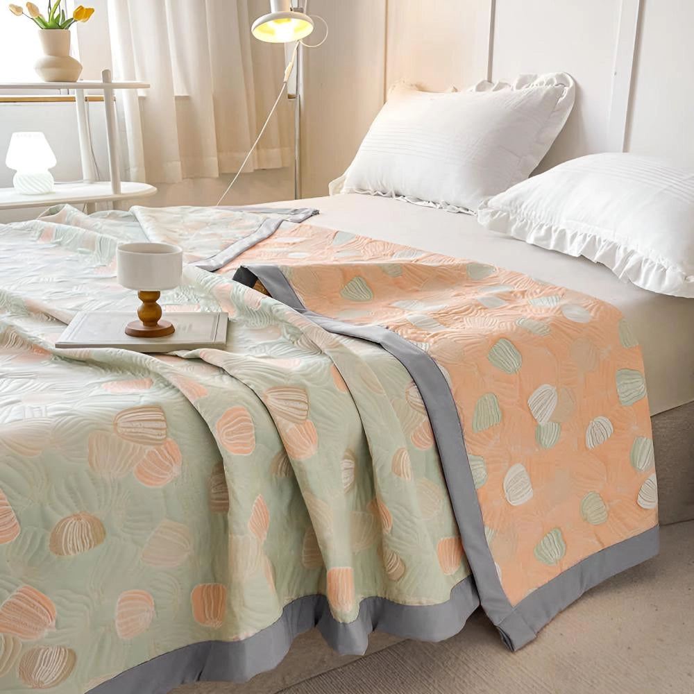 Ocean-inspired duvet cover with a pastel beach theme, featuring seashell patterns, displayed on a neatly made bed with coordinating pillows and a bed skirt in a cozy, well-decorated bedroom interior.