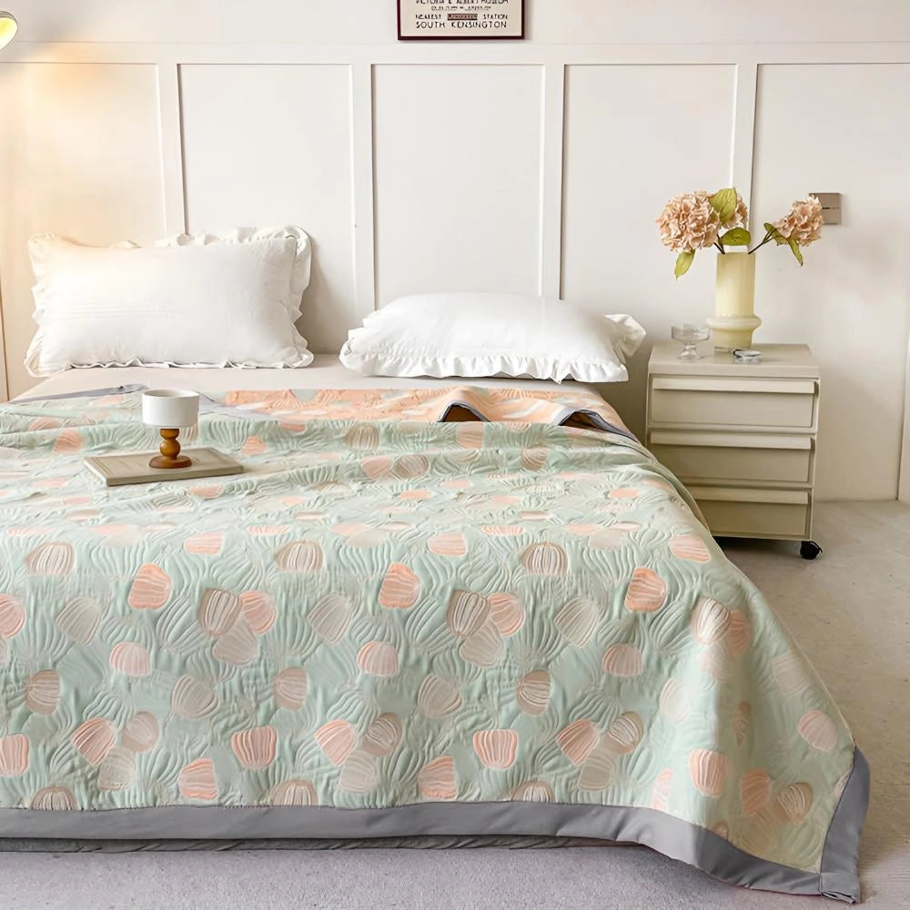 Ocean-inspired duvet cover with a pastel beach theme featuring seashell patterns, placed on a neatly made bed in a cozy, well-furnished bedroom with wooden accents and soft, comfortable textiles.
