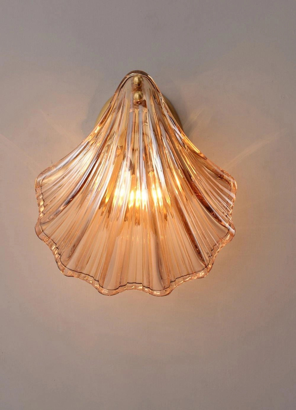 Gold Shell Wall Sconce with Nautical Coastal Seashell Design, featuring amber lighting and metal accents.