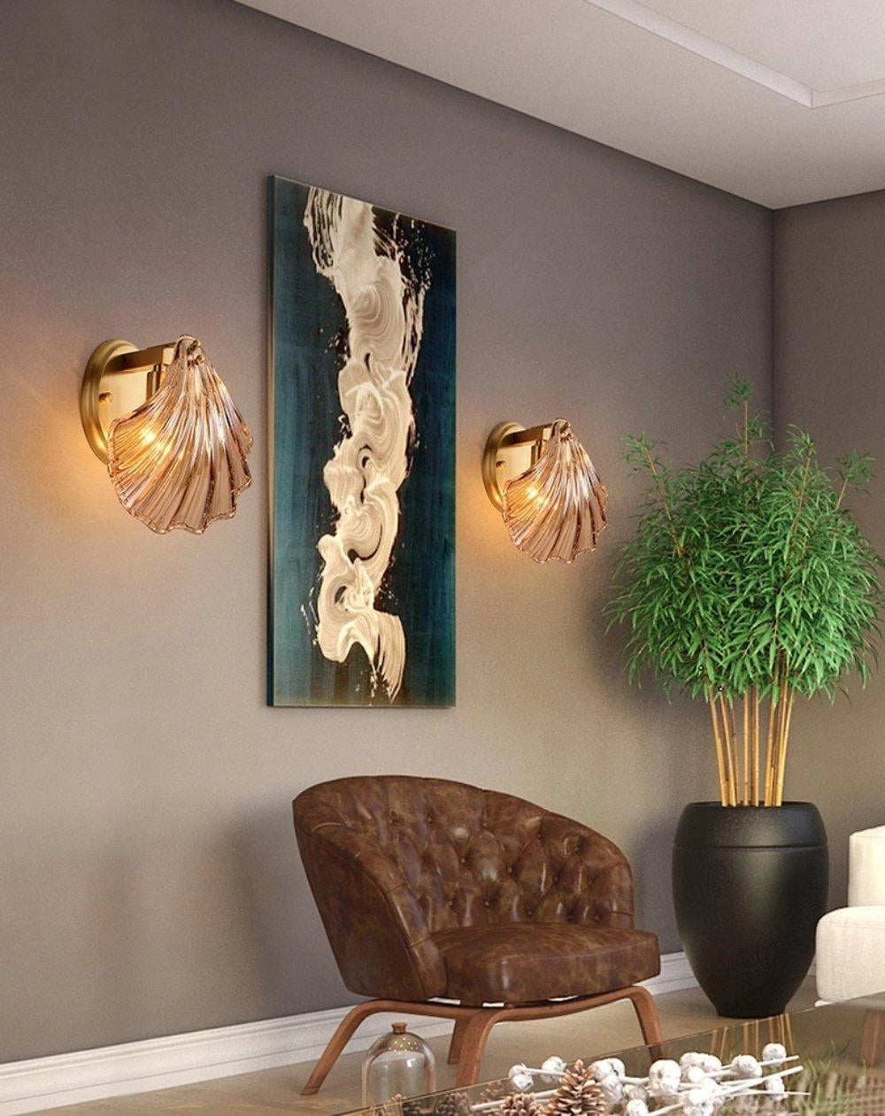Gold shell wall sconce with nautical coastal design, illuminating an indoor space with houseplants and wooden flooring.