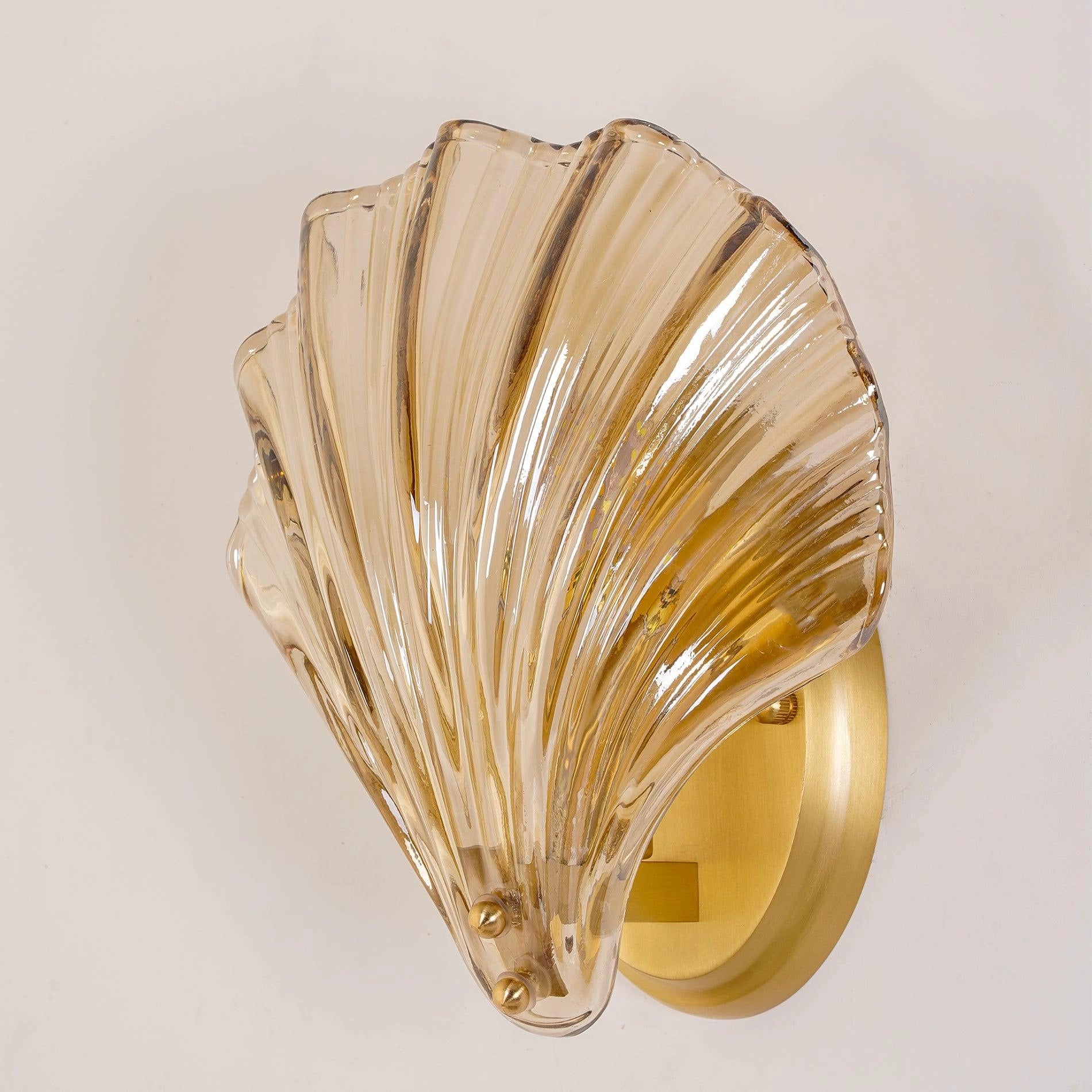 Gold Nautical Coastal Seashell Wall Sconce Light Fixture with a seashell-shaped design, featuring a blend of metal and glass materials.