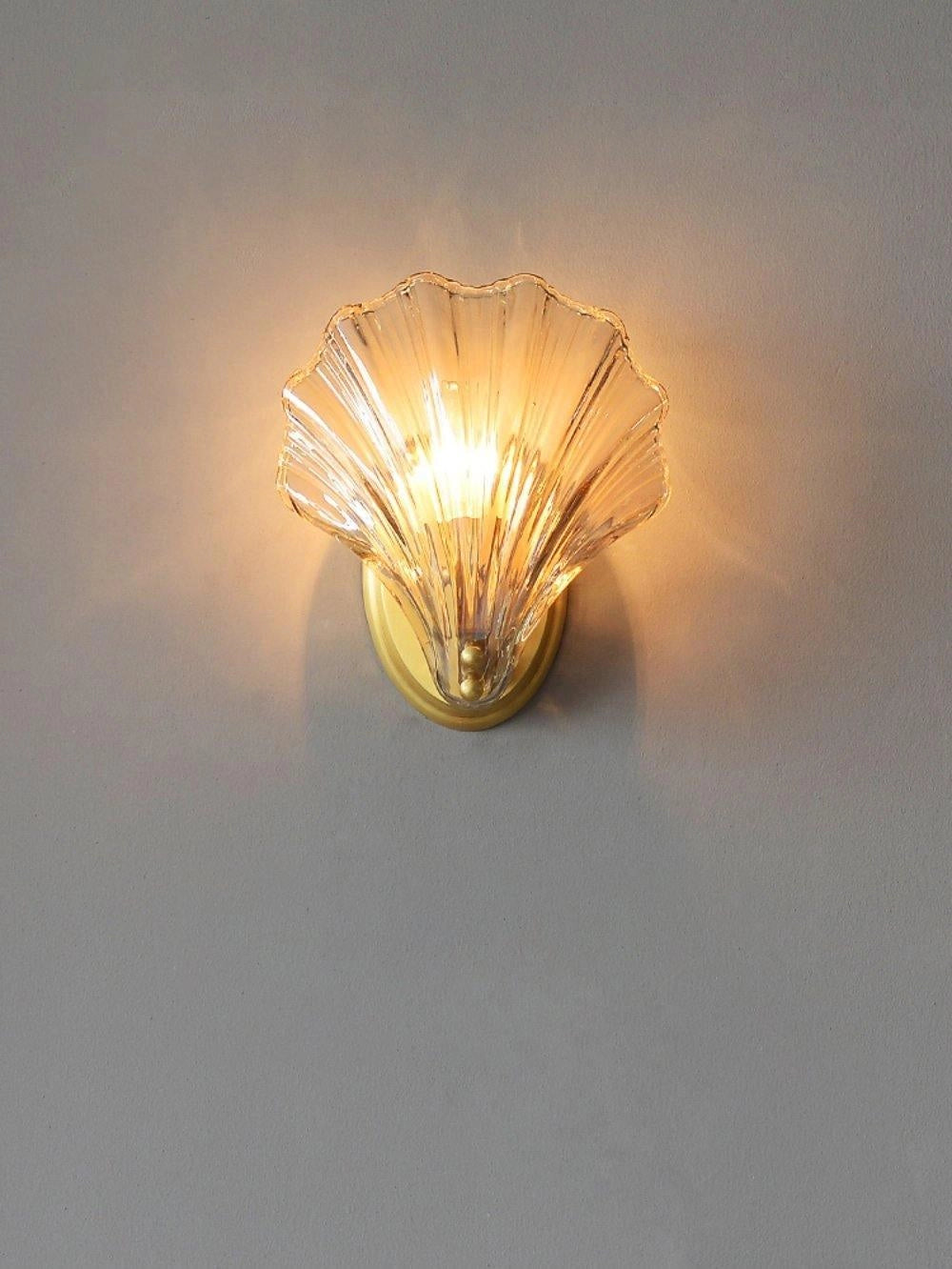 Gold Shell Wall Sconce - Nautical Coastal Seashell Light Fixture mounted on a wall.