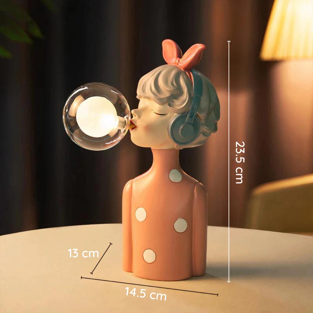 Artistic and modern desk lamp featuring a unique hazel-colored singer figurine design, incorporating elements of wood and metal. The figurine, resembling a toy, is adorned with eyewear and is positioned next to a small plant. The lamp offers a stylish and creative decor lighting solution.