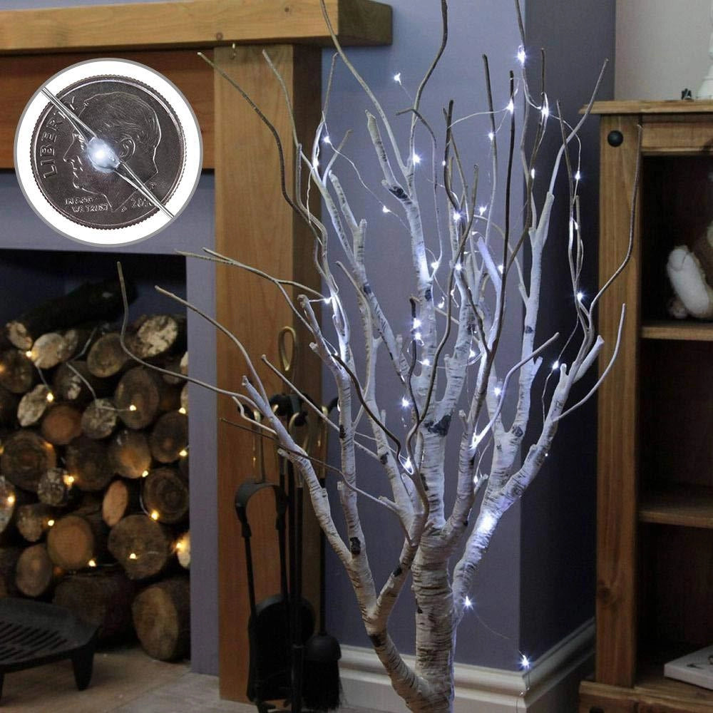 Solar powered outdoor LED fairy lights entwined on twigs and branches against a wooden wall, illuminating a space with an eco-friendly glow.