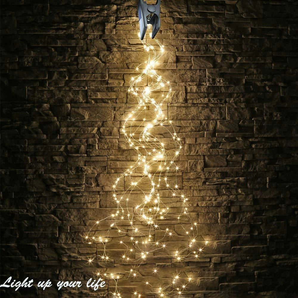 Solar powered outdoor LED fairy lights illuminating a wooden structure against a dark, starry night sky.