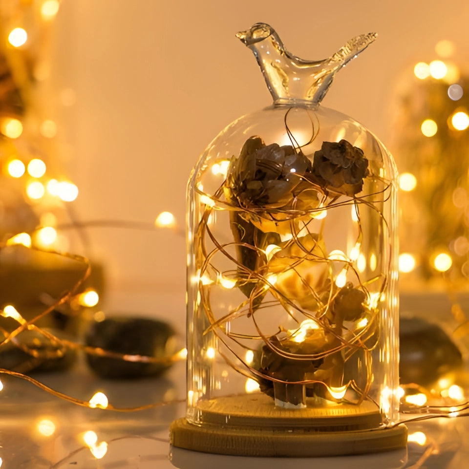 Solar powered outdoor LED fairy lights with a warm amber glow, intertwined with branches resembling gold and twig decorations, ideal for eco-friendly and waterproof Christmas ornamentation.