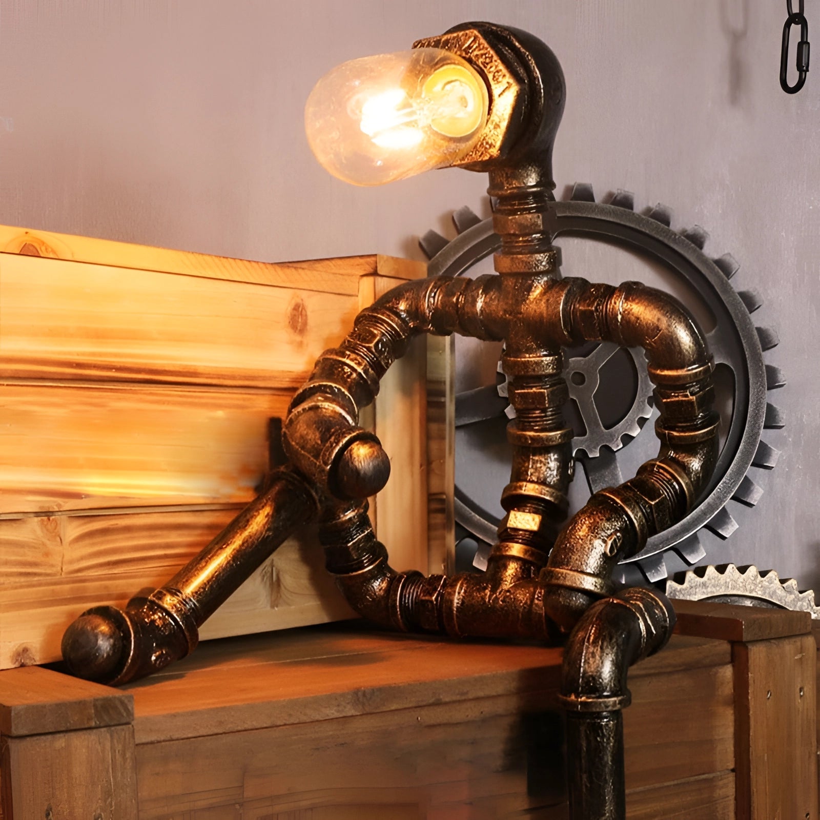 Vintage steampunk industrial pipe table lamp with a metal base and amber light, featuring intricate gear details and a hardwood accent, creating an antique and artistic lighting fixture.