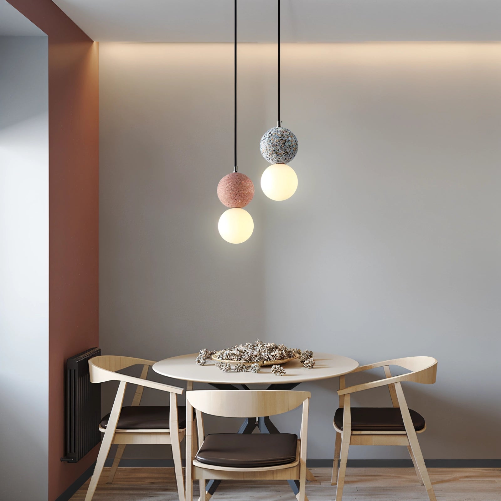 Spherical pendant light with a terrazzo finish, featuring minimalist concrete design, hanging above a wooden table in a modern interior setting.