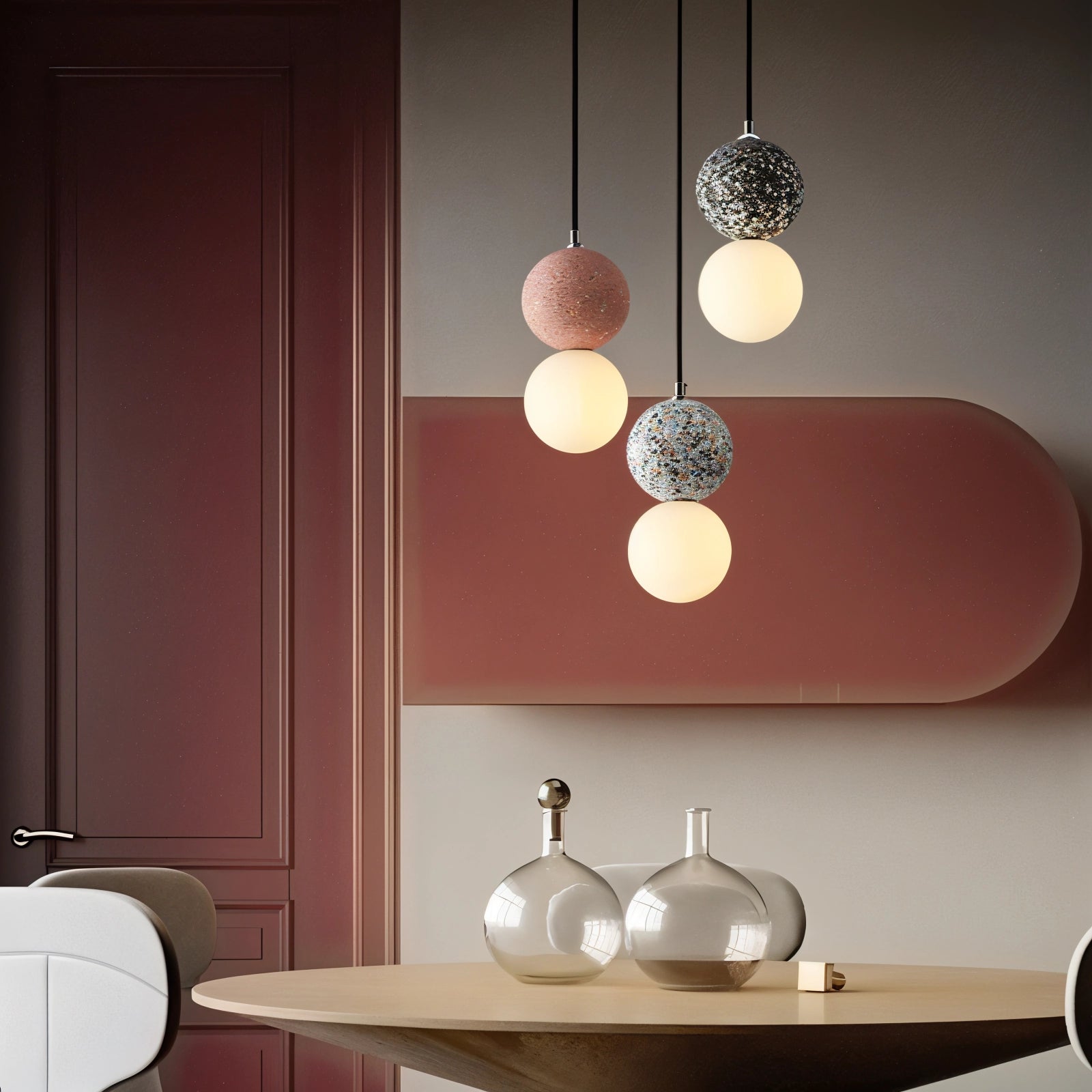 A minimalist terrazzo spherical pendant light fixture hanging from a ceiling, featuring a white concrete finish, illuminating a modern interior space with wood and white elements.
