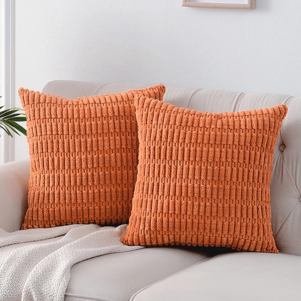 Orange textured corduroy cushions on a beige sofa, featuring a 45x45cm size, presented in a 2-pack with a lumbar design, enhancing comfort and adding a stylish touch to home decor.