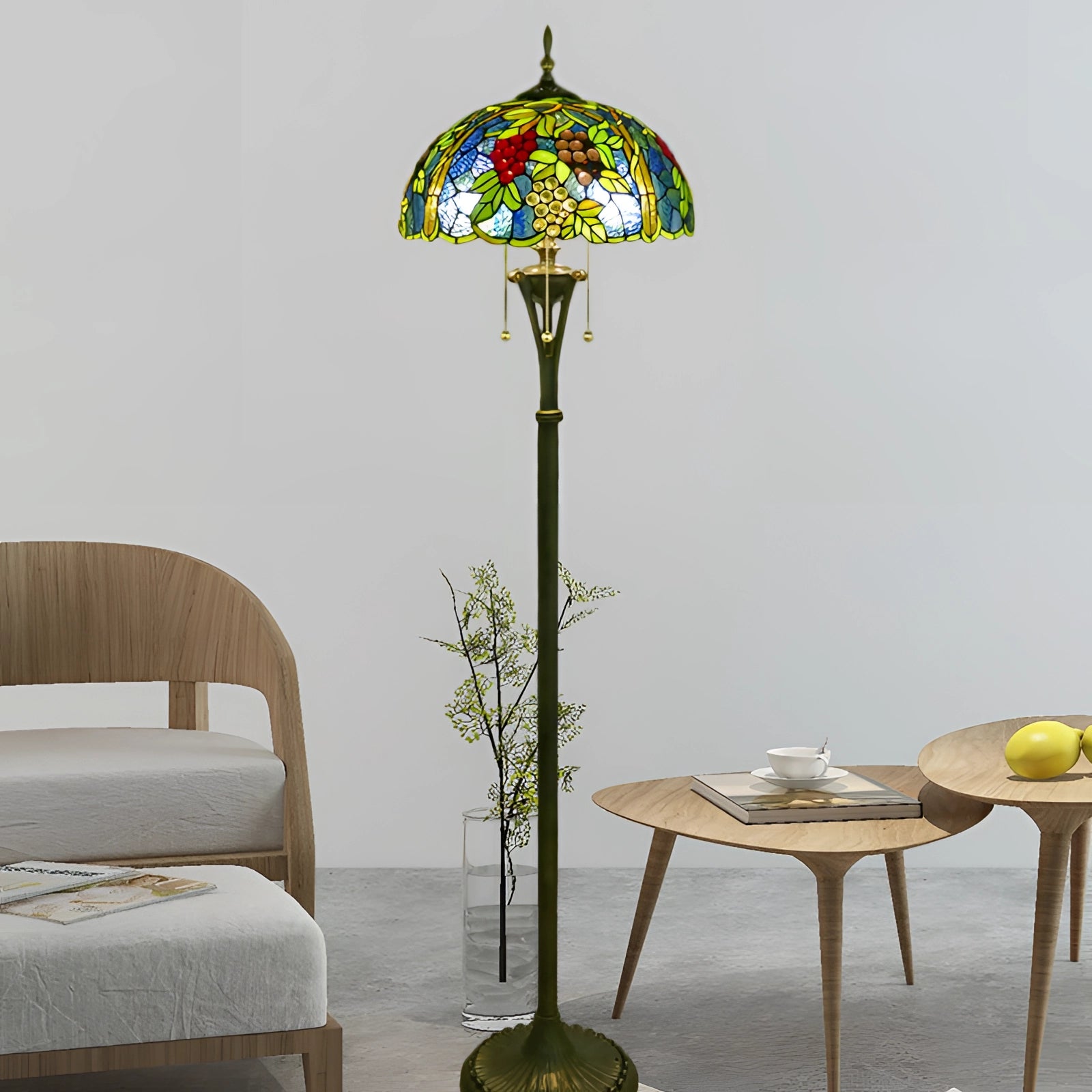 Tiffany-style floor lamp featuring a stained glass peacock feather design, casting a warm yellow glow, placed beside wooden furniture and a potted plant.