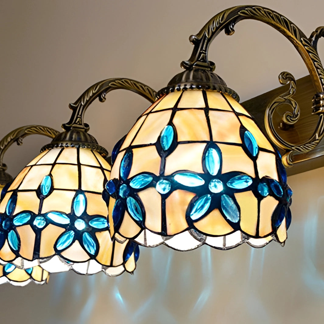 Tiffany-style vintage flower wall lamp featuring a stained glass lighting fixture with intricate patterns and vibrant tints and shades, showcasing symmetrical floral designs encased in a metal frame.