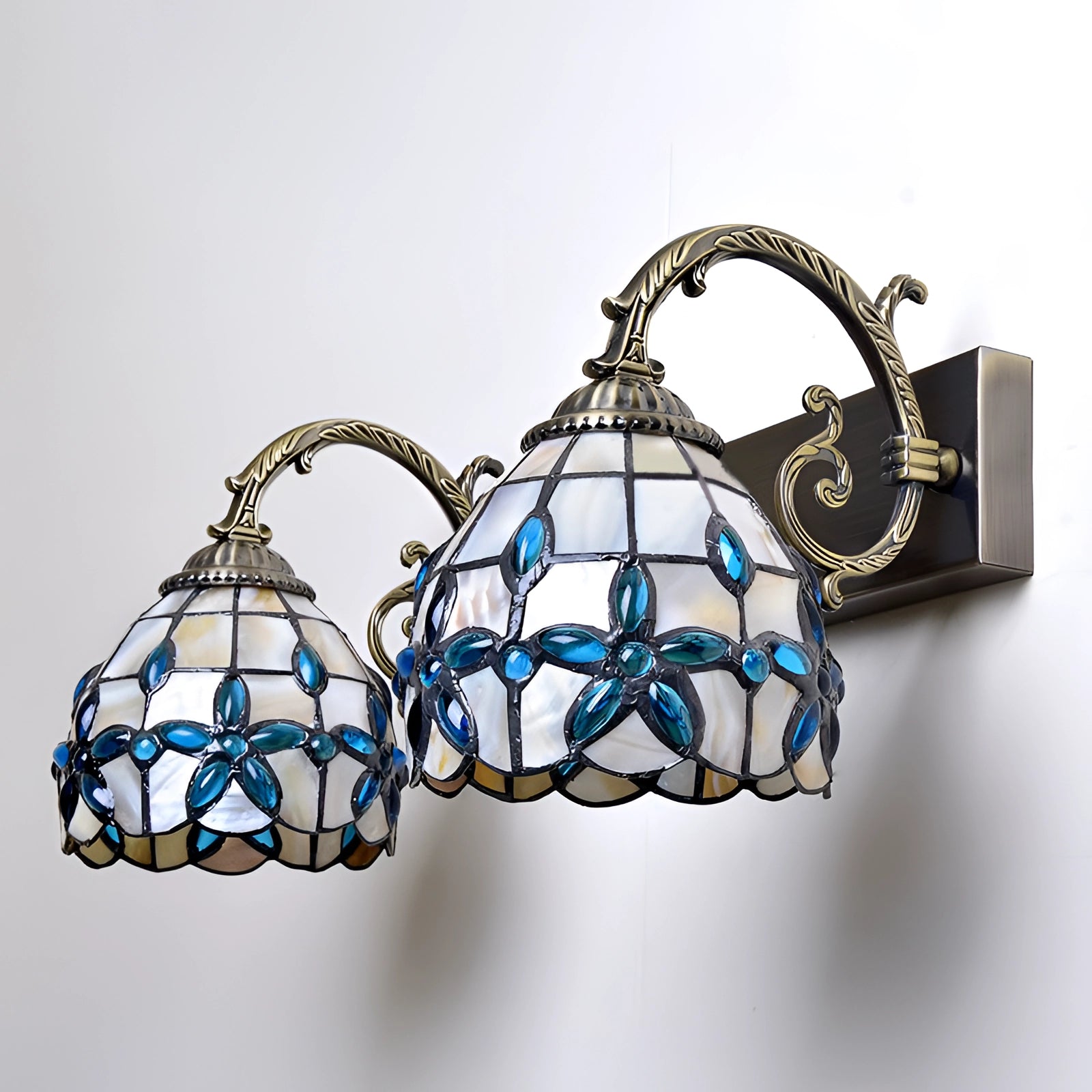 Tiffany-style vintage flower wall lamp featuring intricate stained glass design in vibrant patterns and electric blue hues, resembling an ornamental art piece.