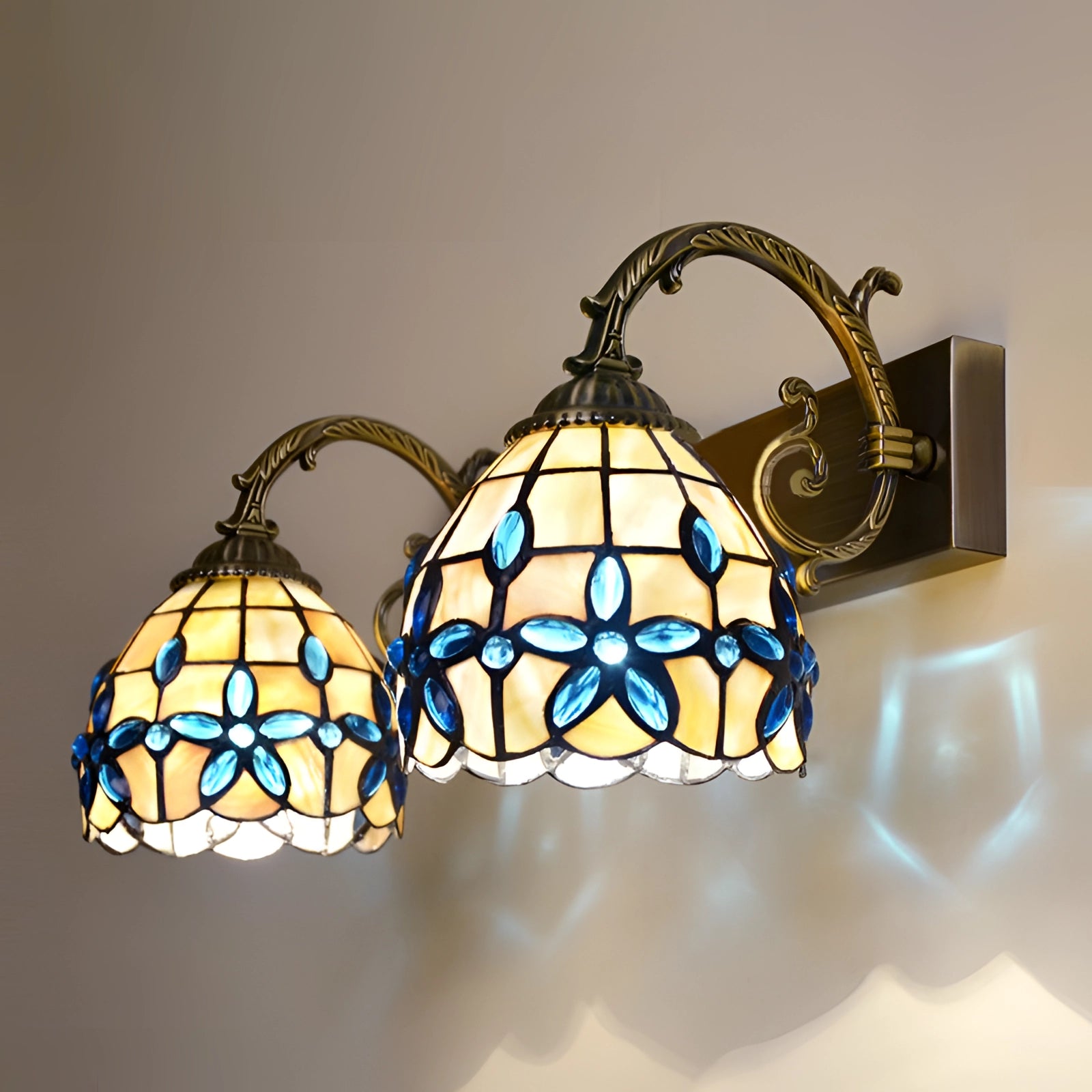 Tiffany-style vintage flower wall lamp featuring a stained glass design with floral patterns, showcasing intricate tints and shades, with two lights providing elegant and artistic illumination.