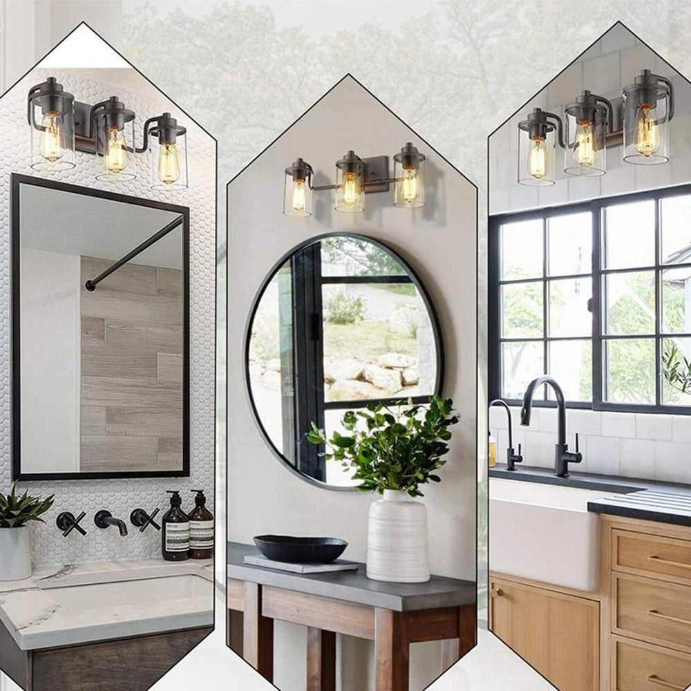 Black metal frame 3-light sconce with triple lantern design and clear glass shades mounted on a wall above a sink in a modern interior setting.