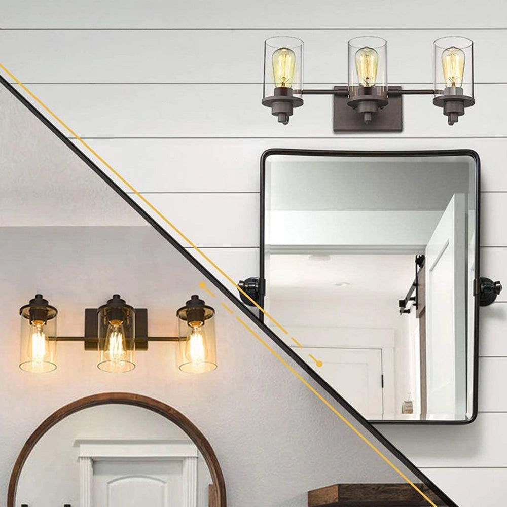 Black metal frame 3-light sconce with clear glass lantern design mounted on a white wall, illuminating an interior space with a contemporary style.