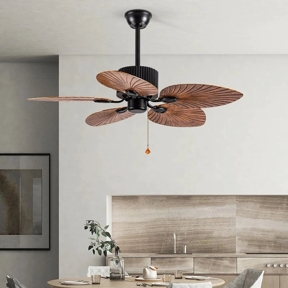 Tropical indoor ceiling fan with black palm leaf blades, featuring a five-blade design, installed in a stylishly decorated interior setting.