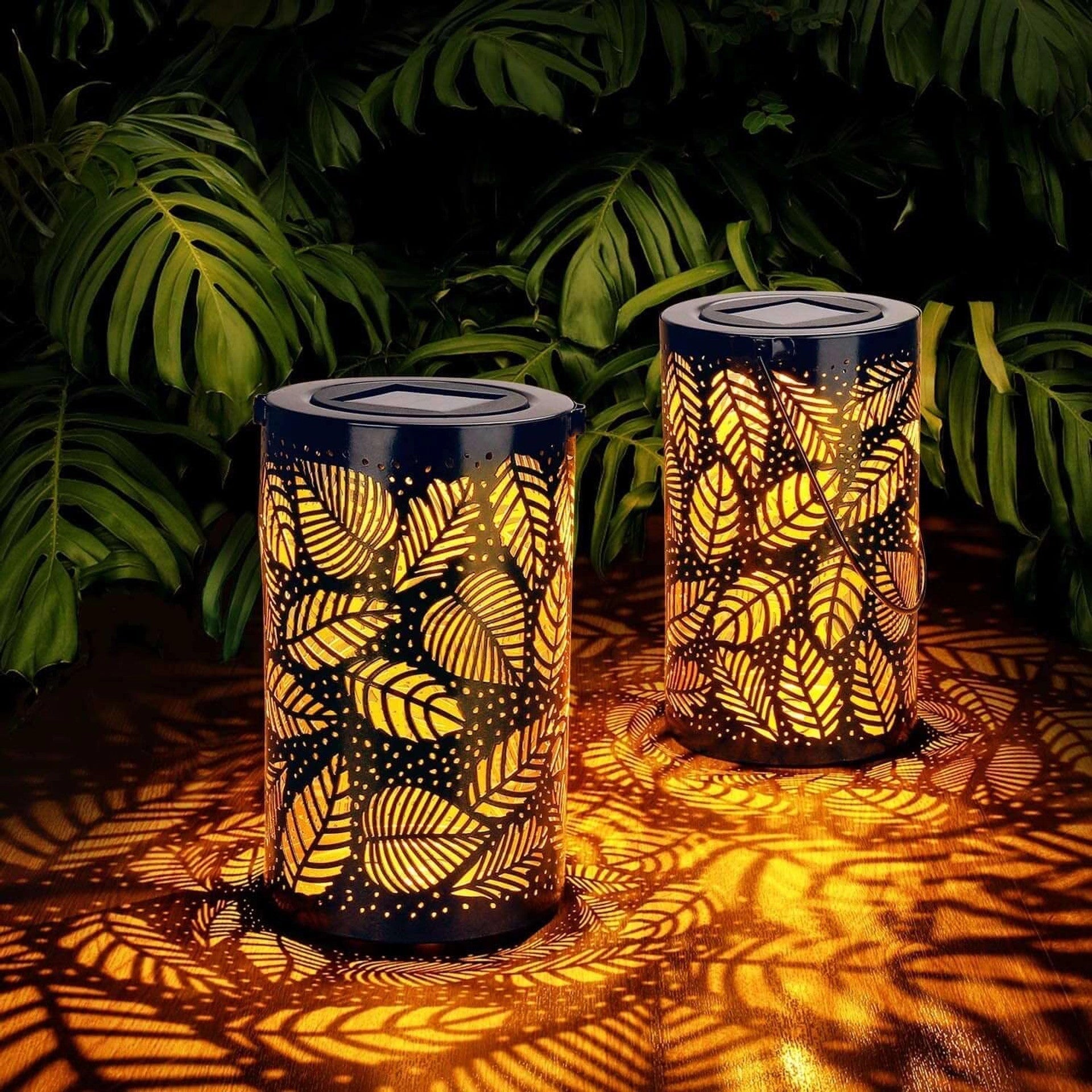 Tropical Leaf LED Solar Lantern in a garden setting with decorative plant design, showcasing a cylinder shape and wood-like texture.