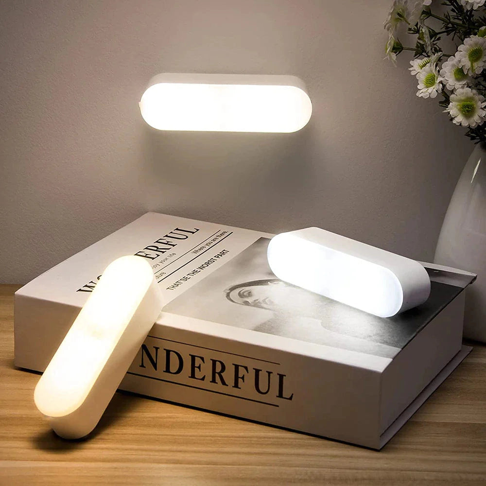 USB LED wireless motion sensor lamp placed on a wooden table, showcasing its compact and energy-efficient design suitable for interior settings.