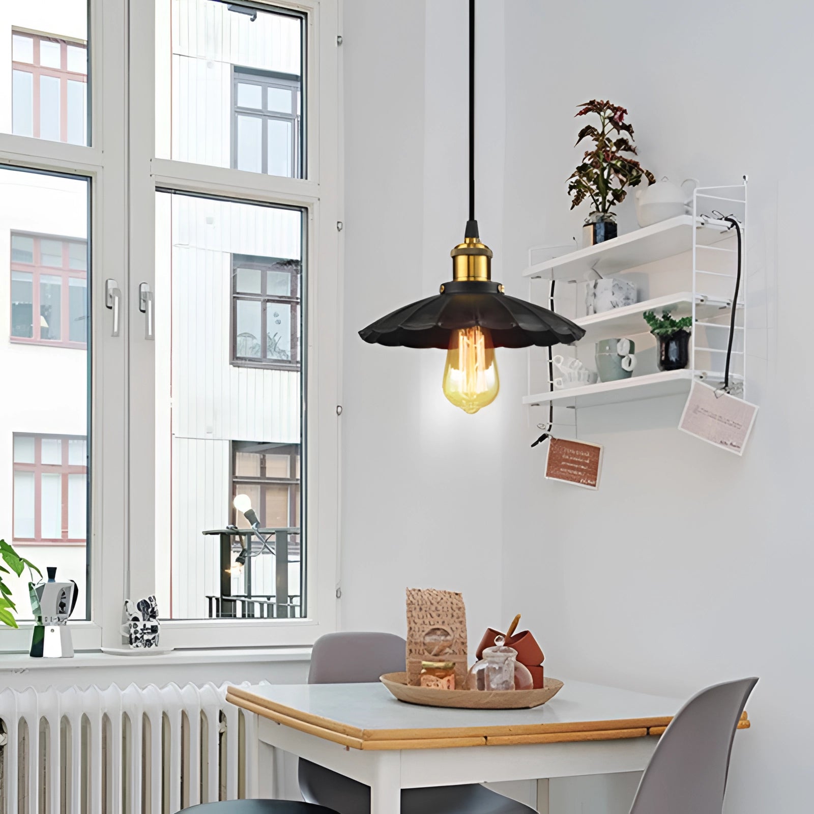 Vintage black Edison bulb pendant light with an industrial metallic dome, measuring 8.7 inches, hanging in a stylish interior space. The room features wooden furniture, including a table and chair, with visible windows and walls that enhance the overall interior design aesthetic.