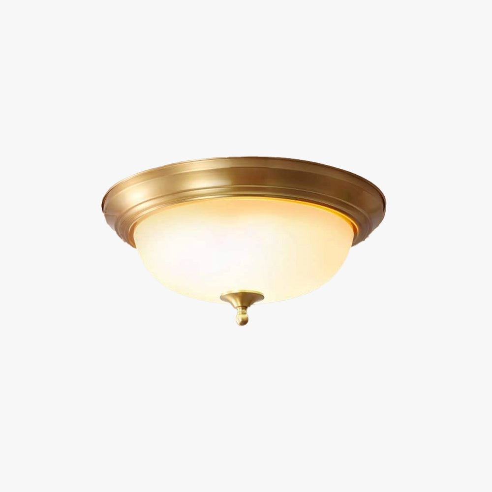 Vintage brass flush mount ceiling light with frosted glass featuring a circular design and metal accents mounted on a ceiling.