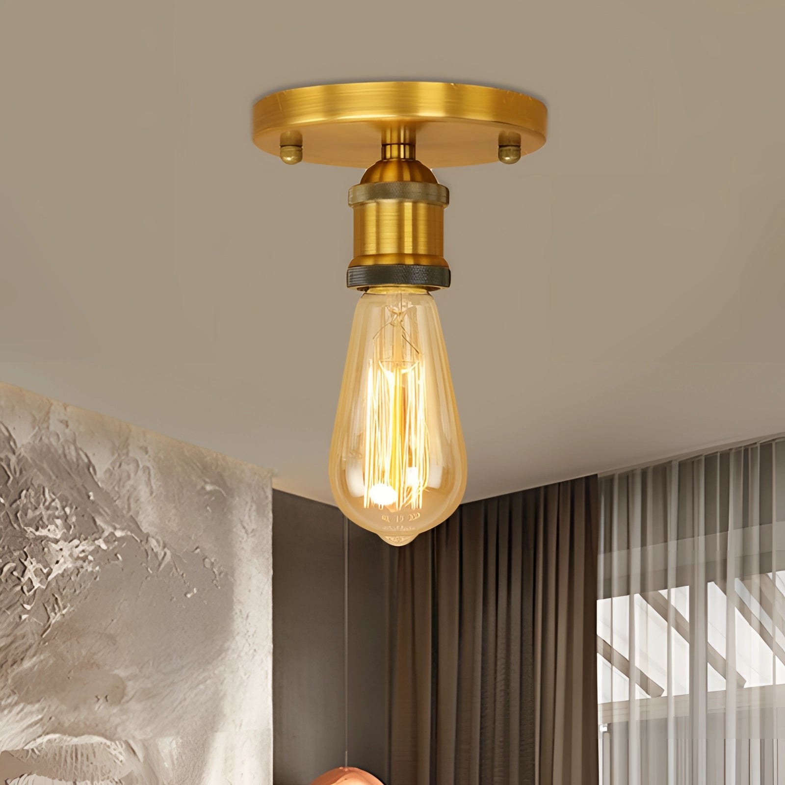 Vintage brass flush mount Edison ceiling fixture in retro industrial style with an amber shade, set against a background featuring curtains and wooden elements.
