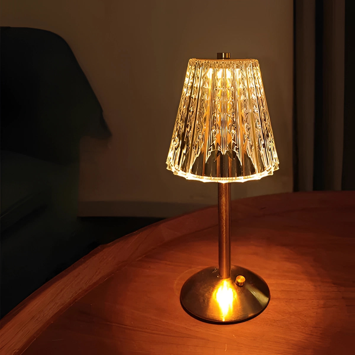 Vintage brass table lamp with a pleated shade, showcasing mid-century modern design, featuring warm amber tones and a composite material base, set on a wooden surface.