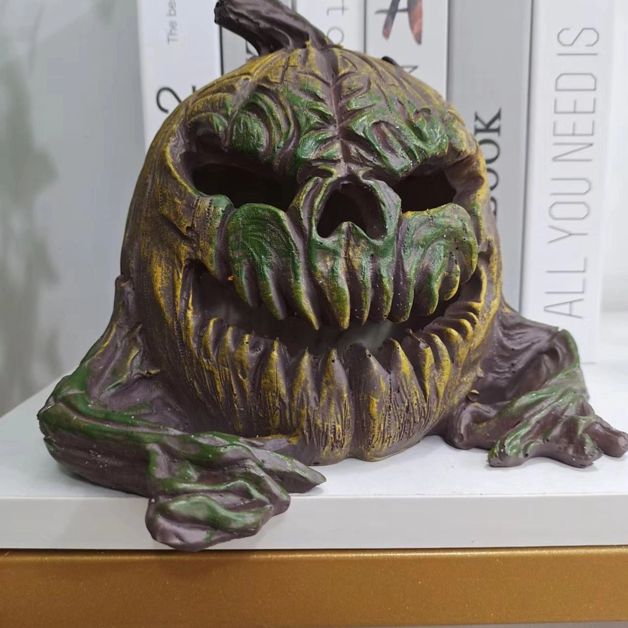 Vintage bronze Halloween pumpkin sculpture with intricate carving details, showcasing a spooky expression with visible head and jaw elements; designed as a unique table centerpiece.
