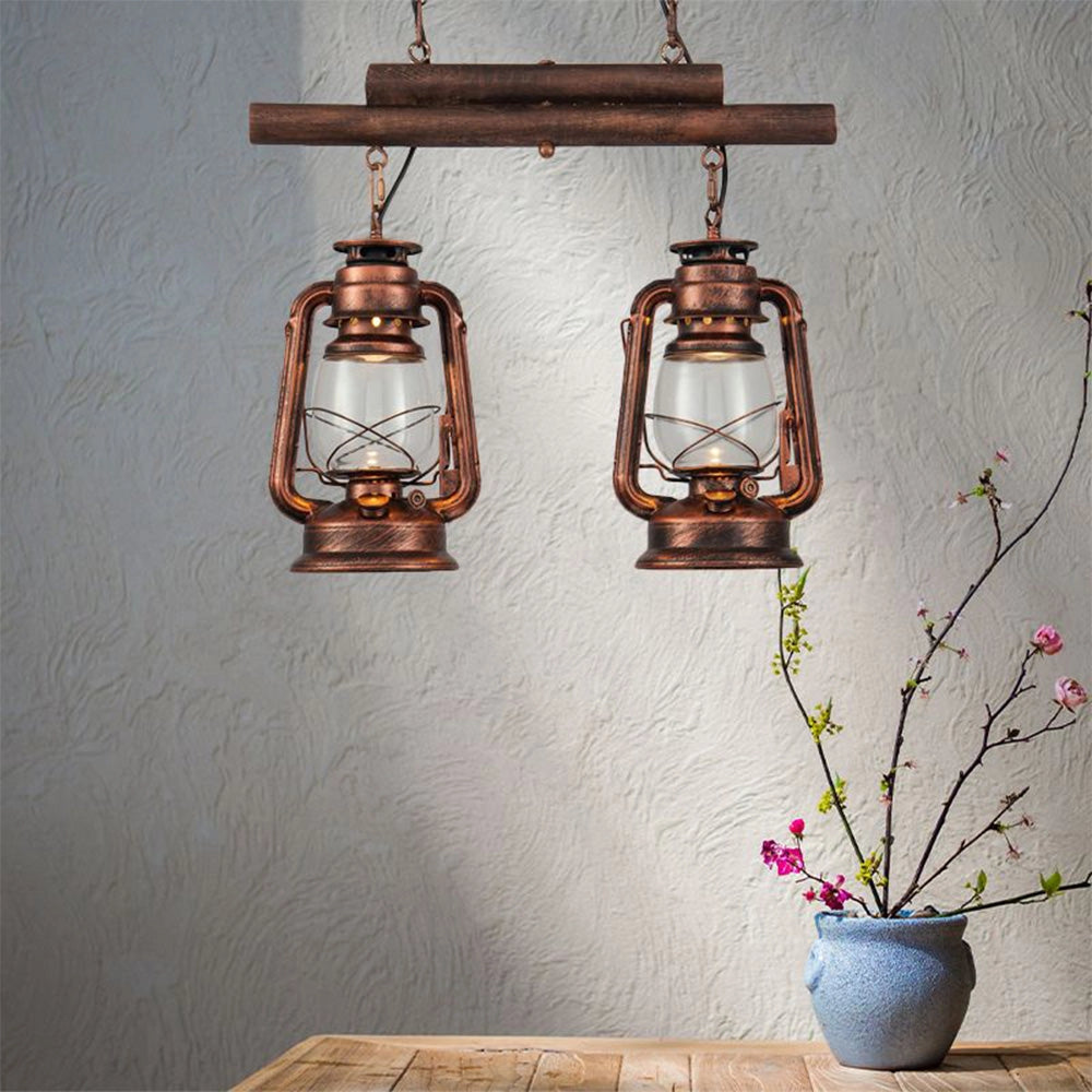 Vintage dual head copper lantern pendant in brass finish hanging above a potted houseplant, with yellow lighting casting warm tones against a wall, evoking nautical and industrial decor.
