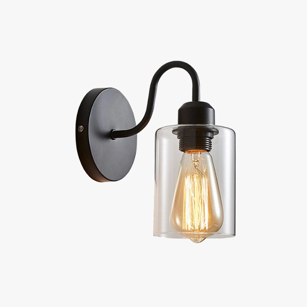 Vintage Edison bulb wall sconce featuring a black metal frame and clear glass shade, mounted on a wooden surface.