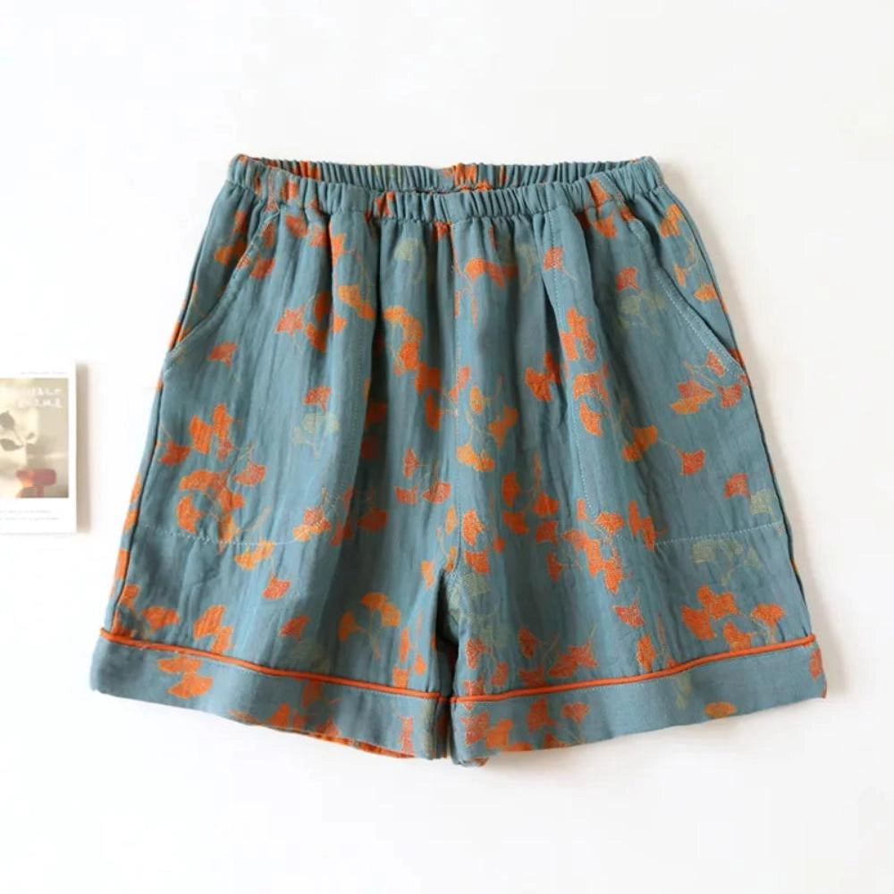 Blue vintage floral bohemian midi skirt with an elastic waist, made of lightweight cotton, displayed against a plant backdrop.