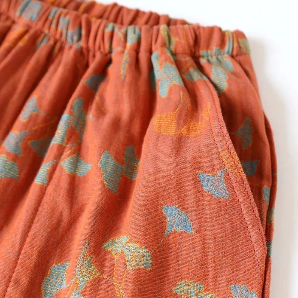 Vintage floral bohemian midi skirt made from lightweight cotton, featuring an elastic waist and a vibrant orange floral pattern.