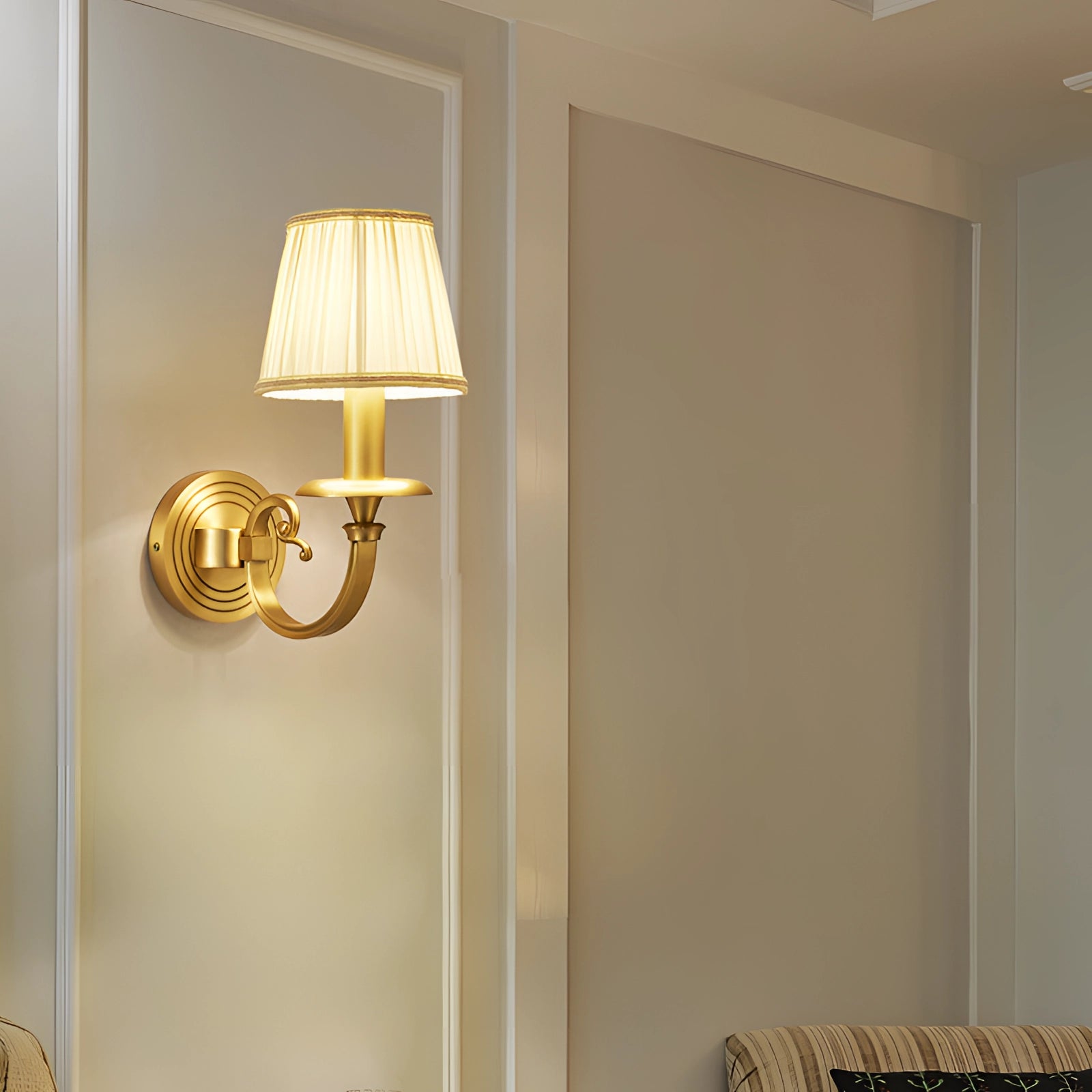 Vintage gold wall sconce made of brass, featuring a rectangular design and tints and shades that complement indoor lighting, mounted on a wooden wall.