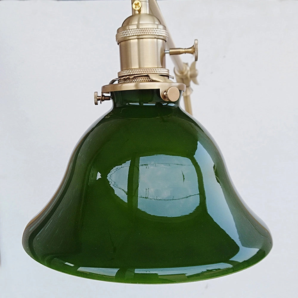 Vintage green enamel wall lamp with brass arm, featuring a classic design, mounted on a wall with a curved brass arm, highlighting the glossy green enamel finish.