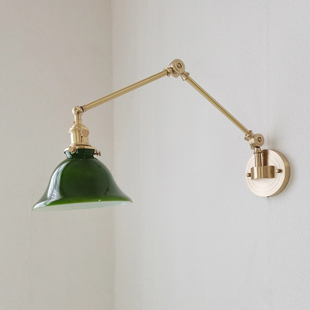 Vintage green enamel wall lamp featuring a brass arm design, with a distinct circular shape reminiscent of an ornamental piece.