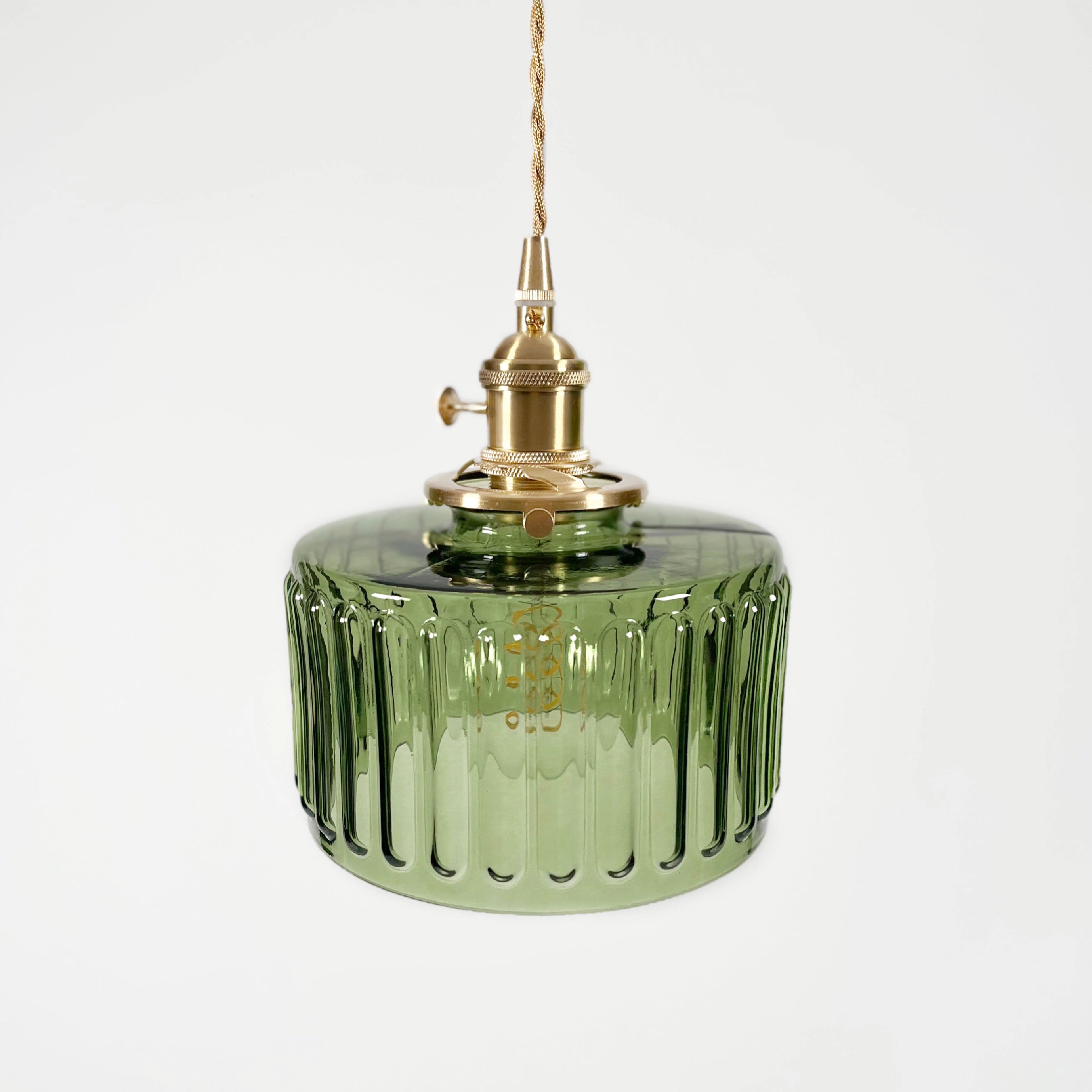 Vintage green glass pendant light with industrial brass fixture featuring striped design, ideal for kitchen settings.