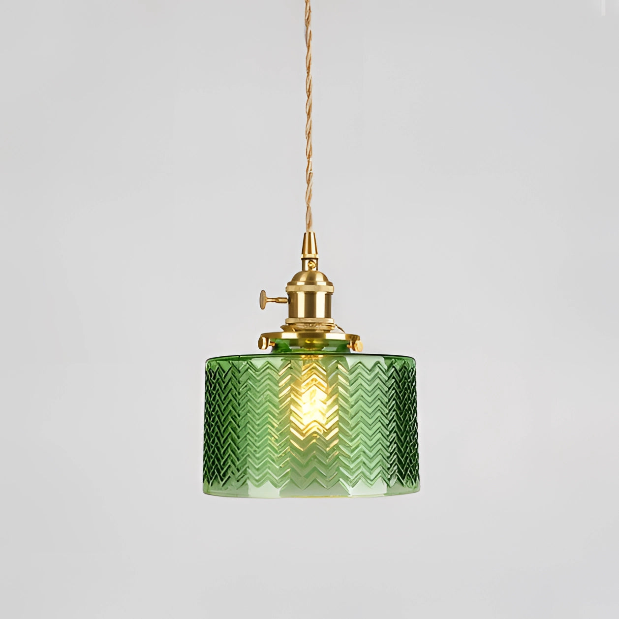 Vintage industrial glass pendant light with green shade and brass fittings, featuring chevron design.