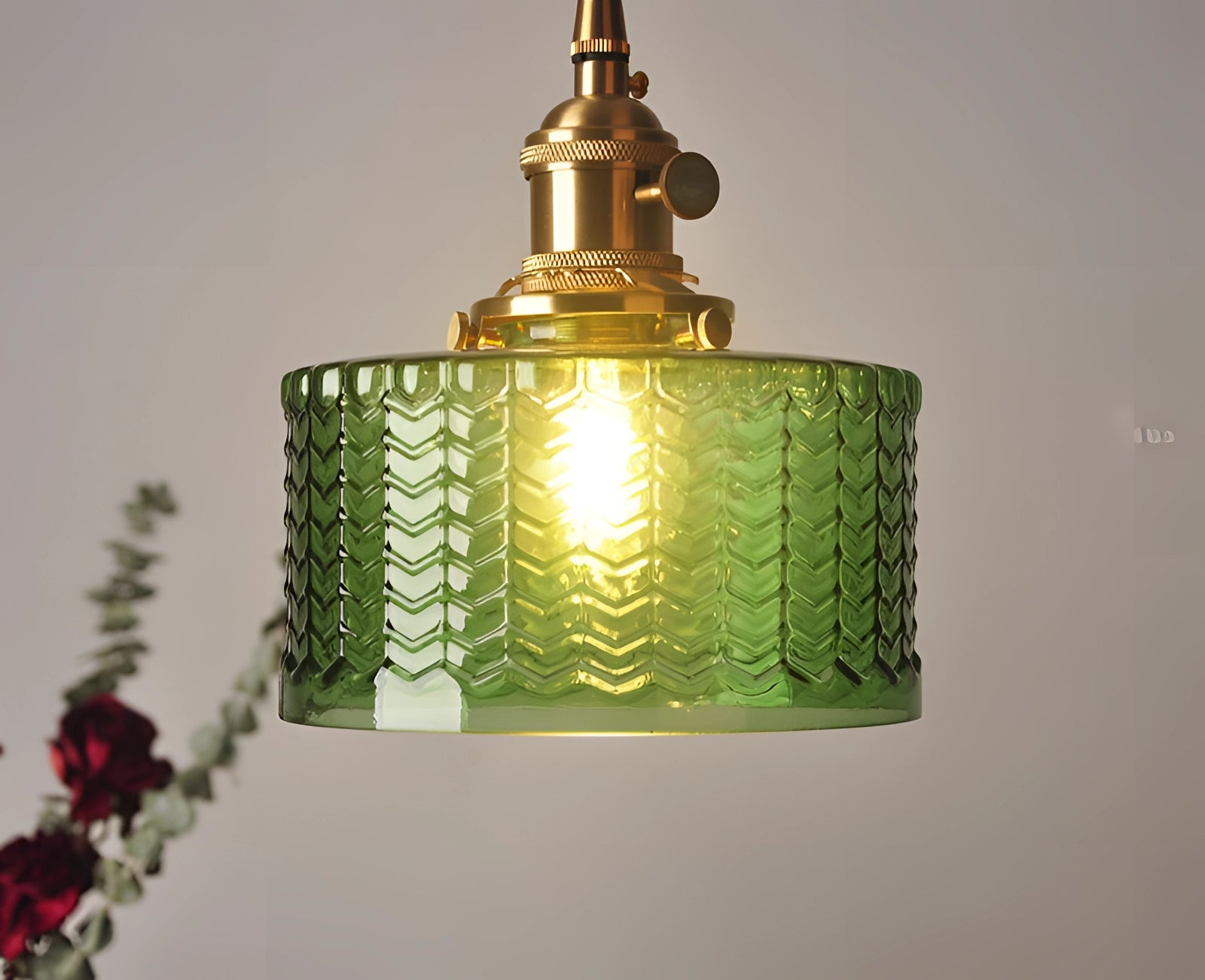 Vintage industrial glass pendant light with green shade and brass fittings, featuring a distinctive amber glass element.