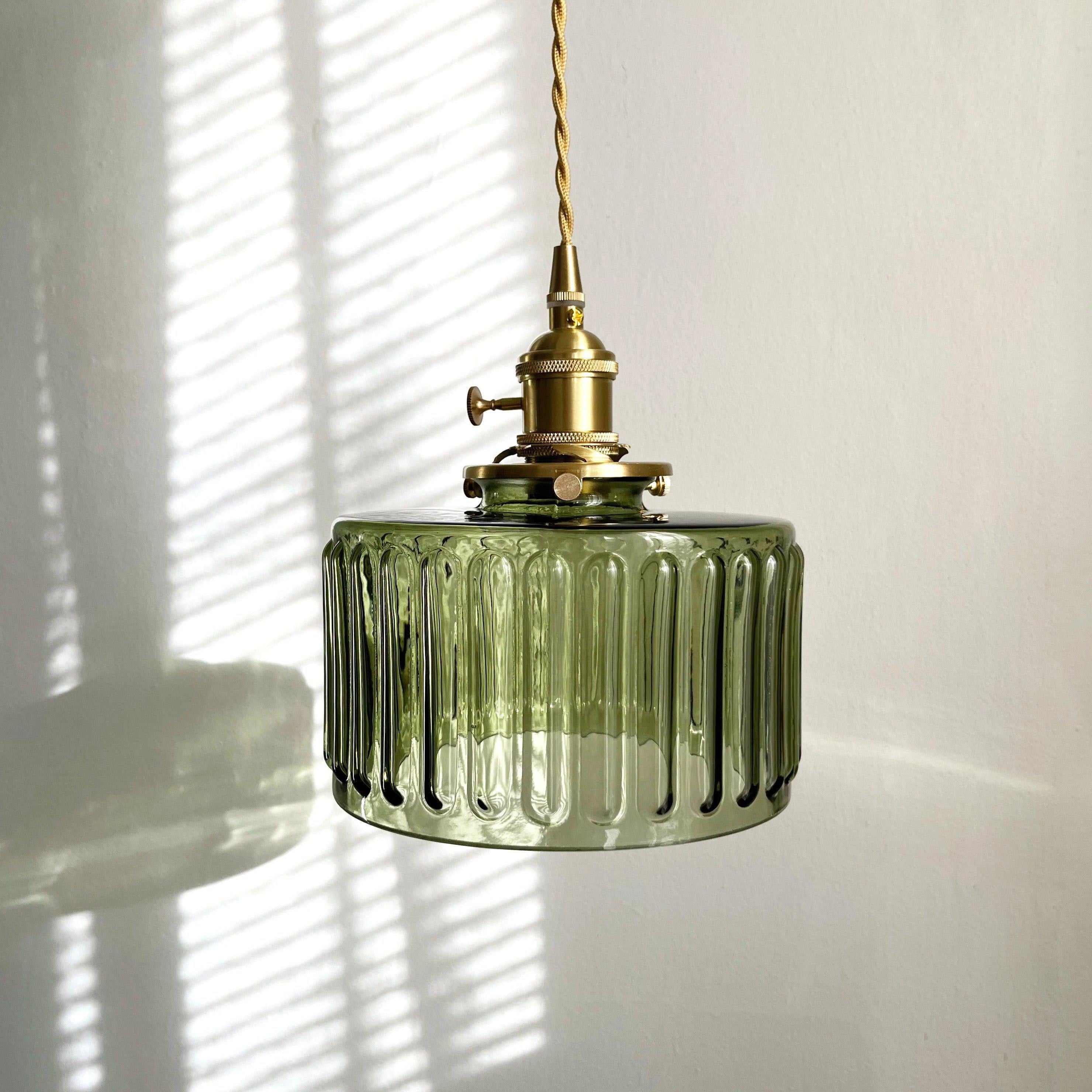 Vintage Industrial Glass Pendant Light with Green Shade and Brass Fittings hanging from ceiling.
